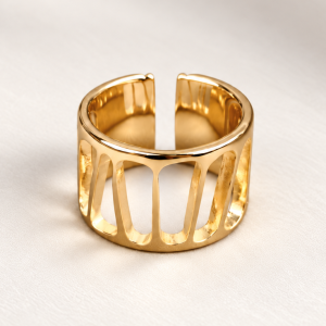 Anillo dorado abierto sobre fondo marfil