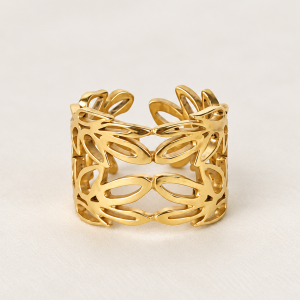 Anillo dorado de filigrana sobre fondo crema
